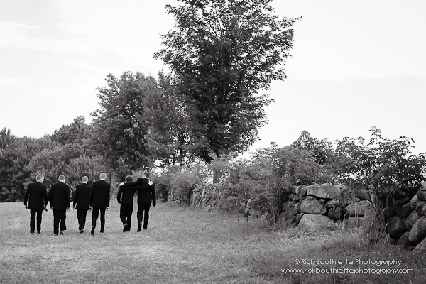 Groomsmen walking through field to ceremony