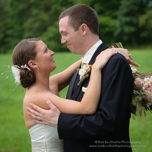 Bride & Groom smiling at each other in field