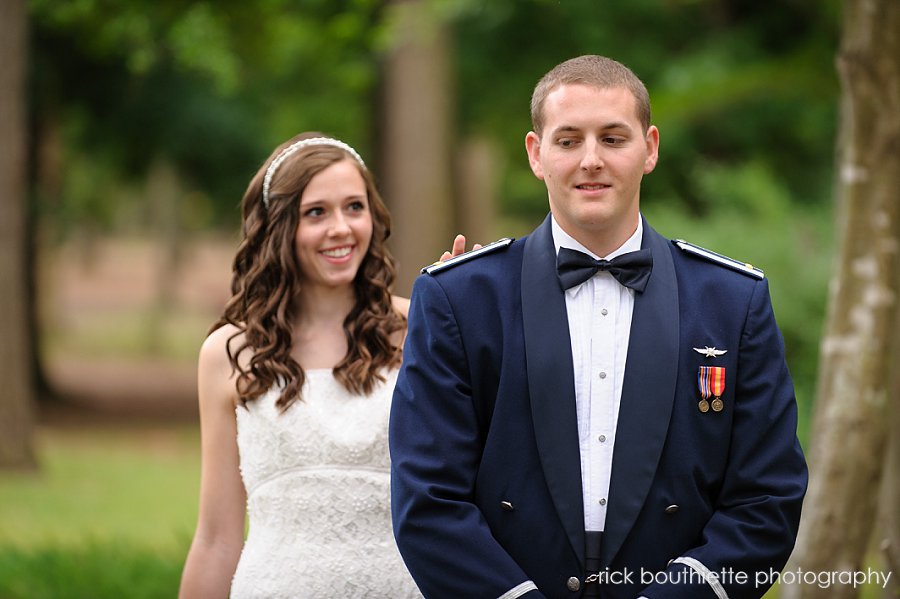 Bride touches groom on shoulder during first look