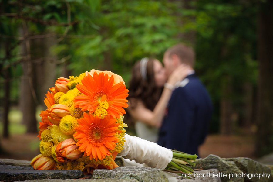 Bride and groom kissing, bouquet in foreground