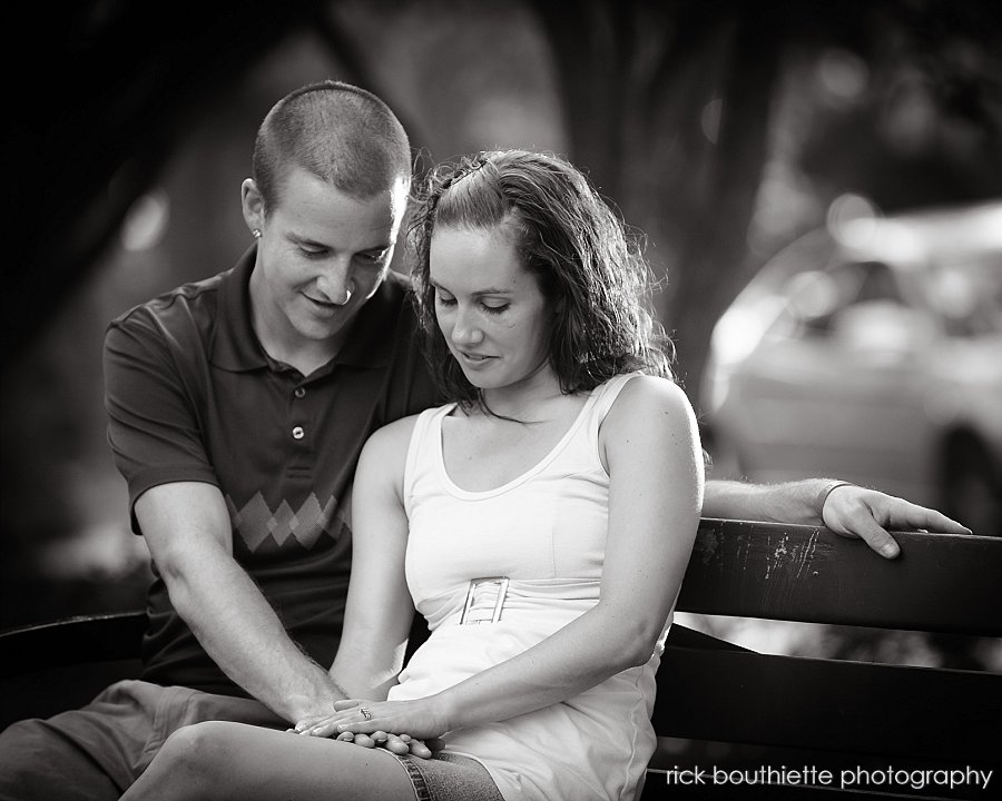 couple staring at engagement ring in park