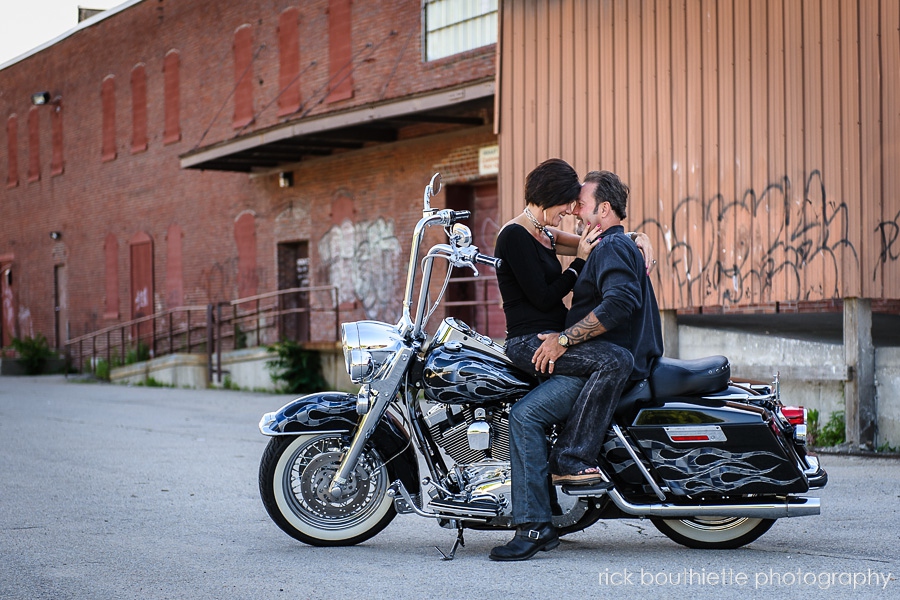 couple on Harley Davidson in back alley at engagement photo session