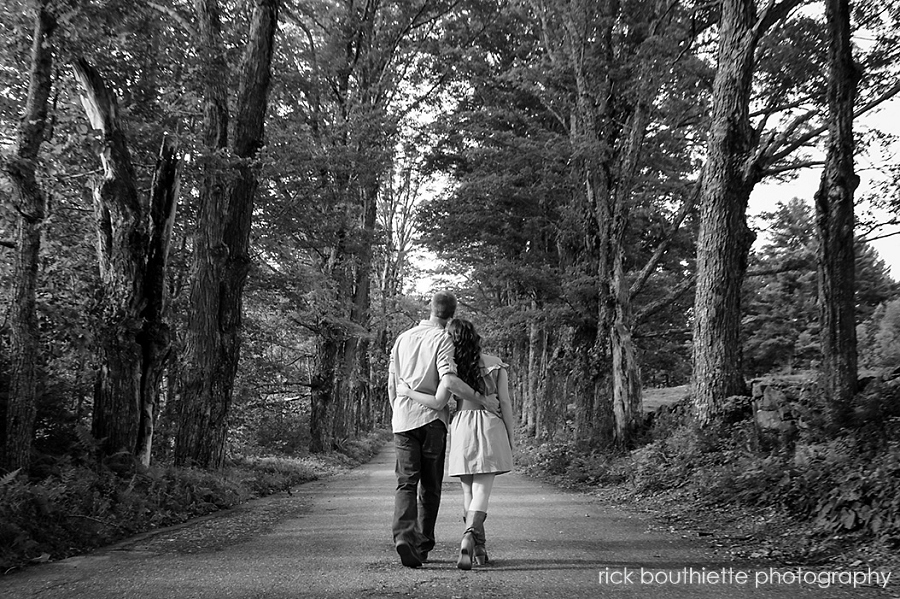 couple walking down Lover's Lane during engagement photo session in b&w