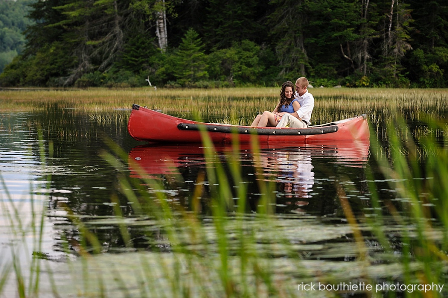 couple hugging in a red canoe during engagement photo session
