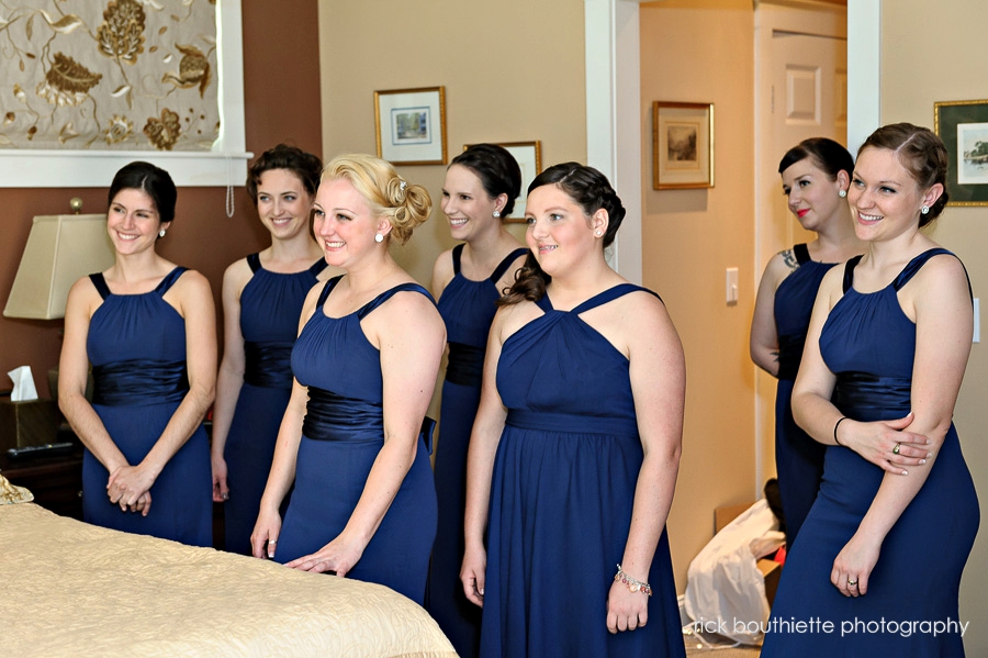 bridesmaids look on as bride prepares for her wedding day