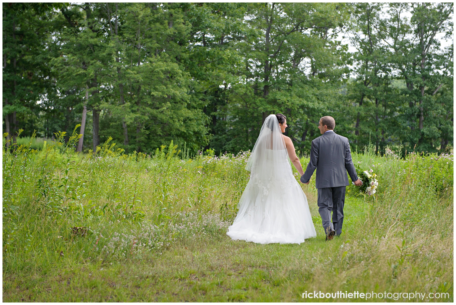 bride & groom walking through field