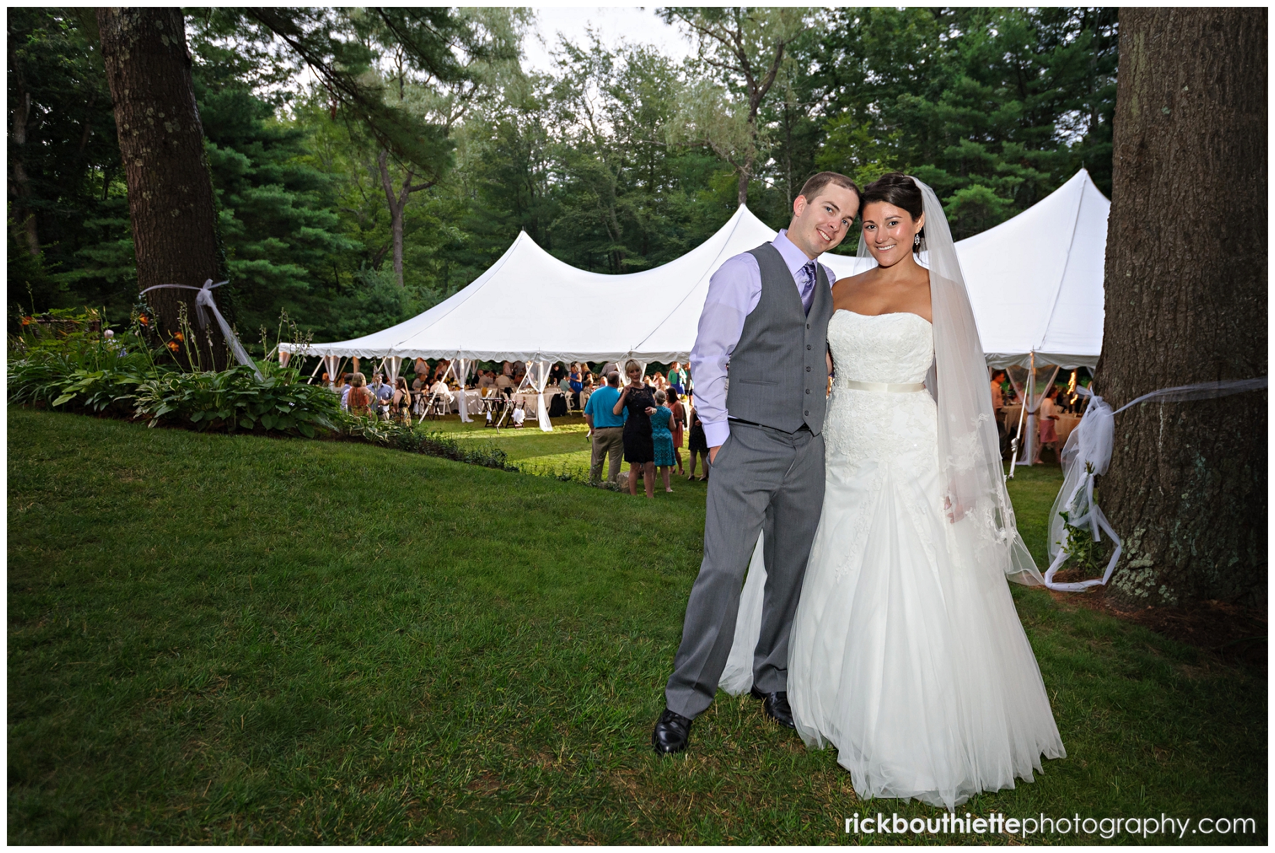 bride & groom at wedding reception, tent in background