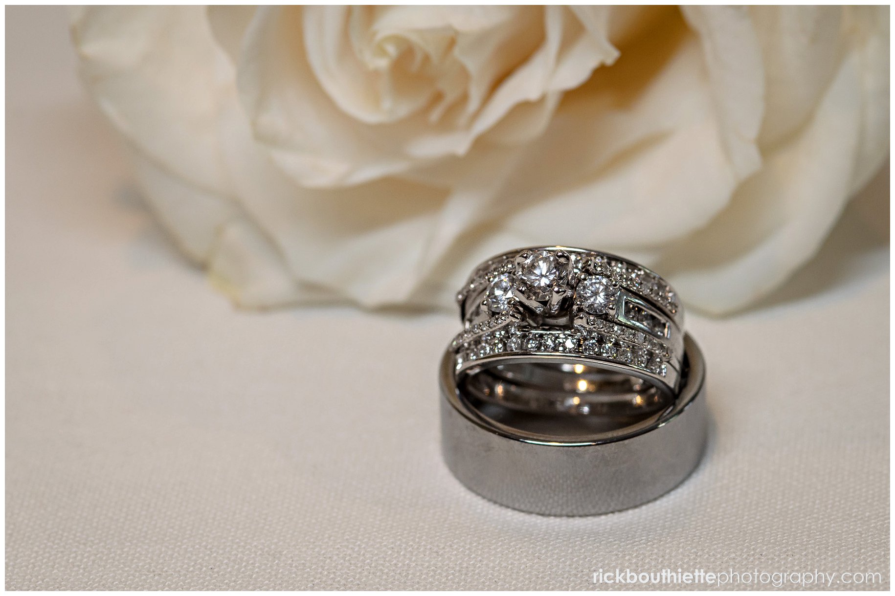 detail of wedding rings with white rose