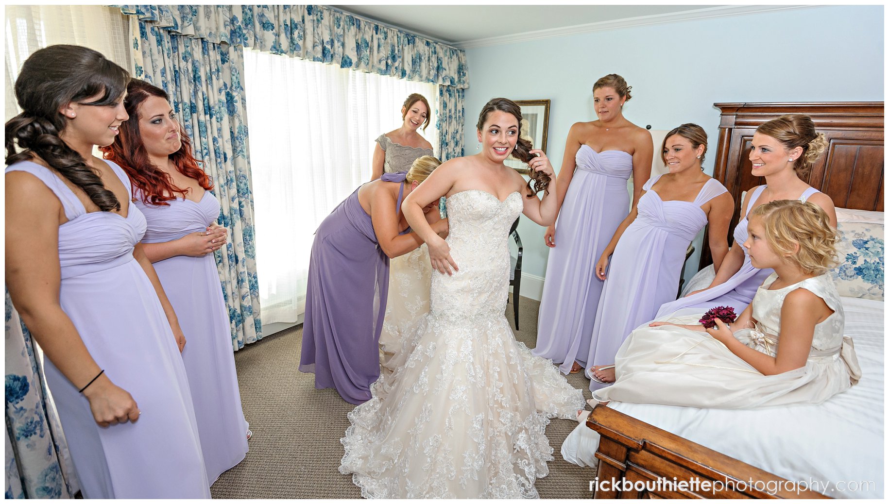 bride getting ready with bridesmaids looking on