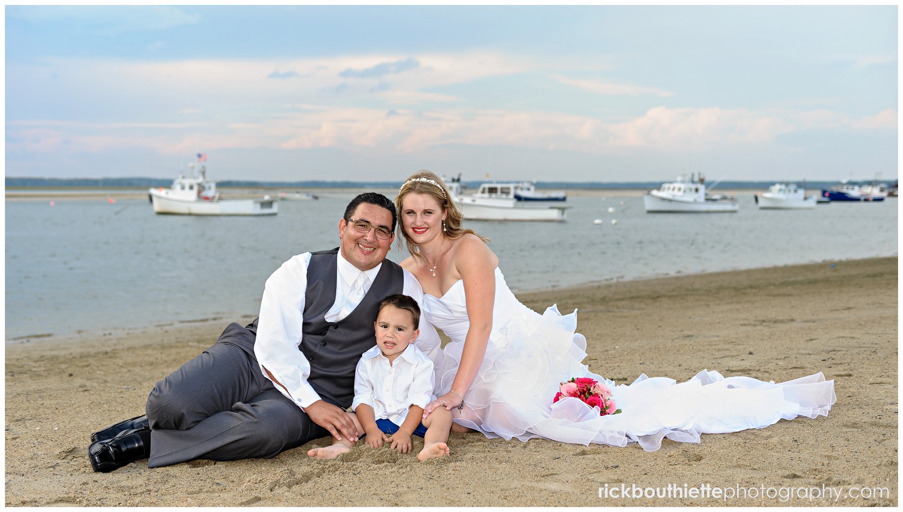 bride and groom on the beach with their young son