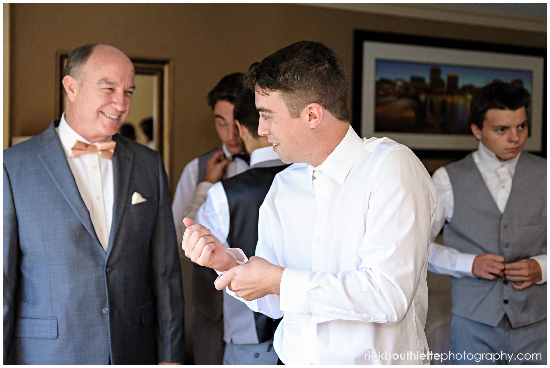 groom getting ready for wedding, father looking on