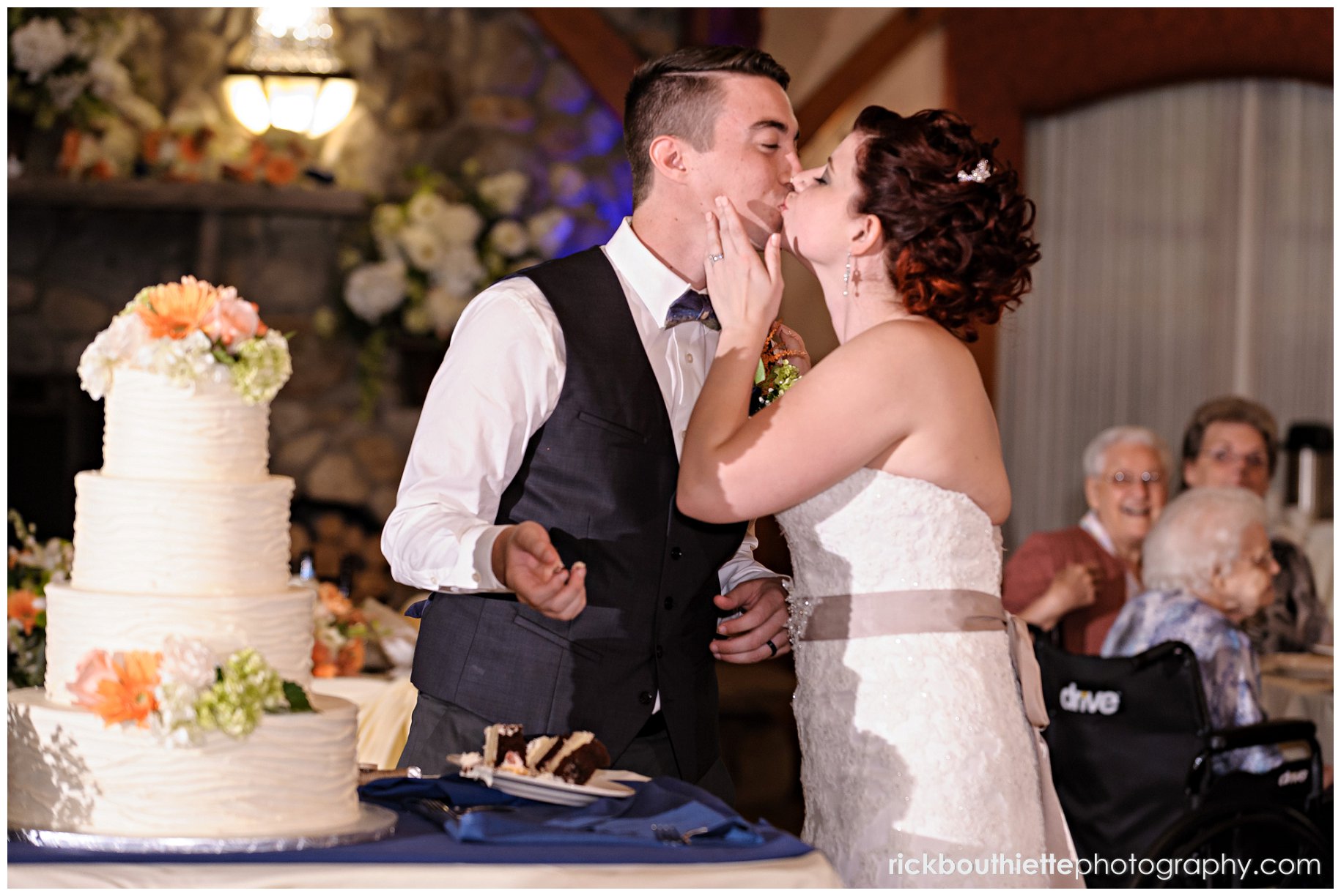 bride & groom kiss after cutting the cake at Tewksbury Country Club wedding