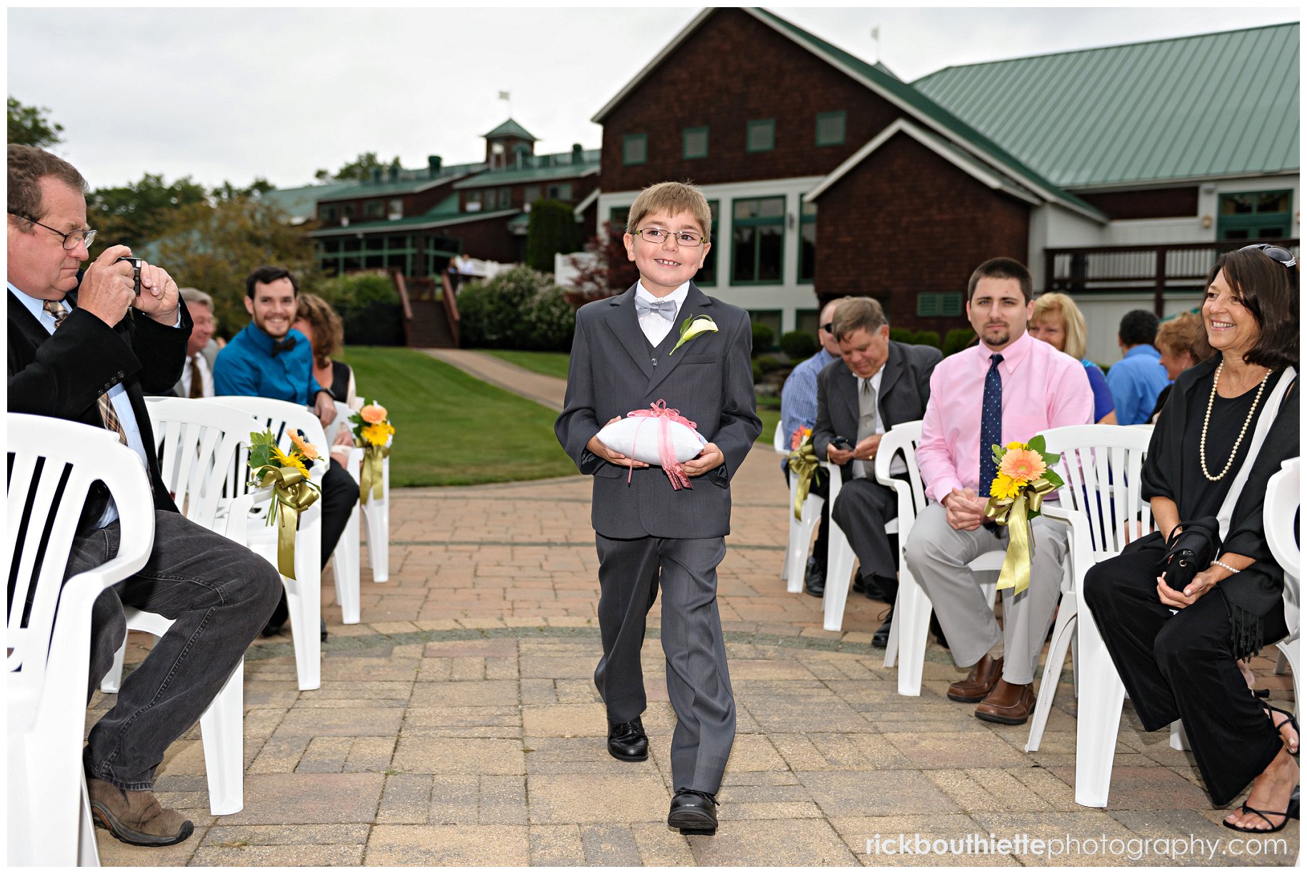 ring bearer walks down aisle at wedding ceremony