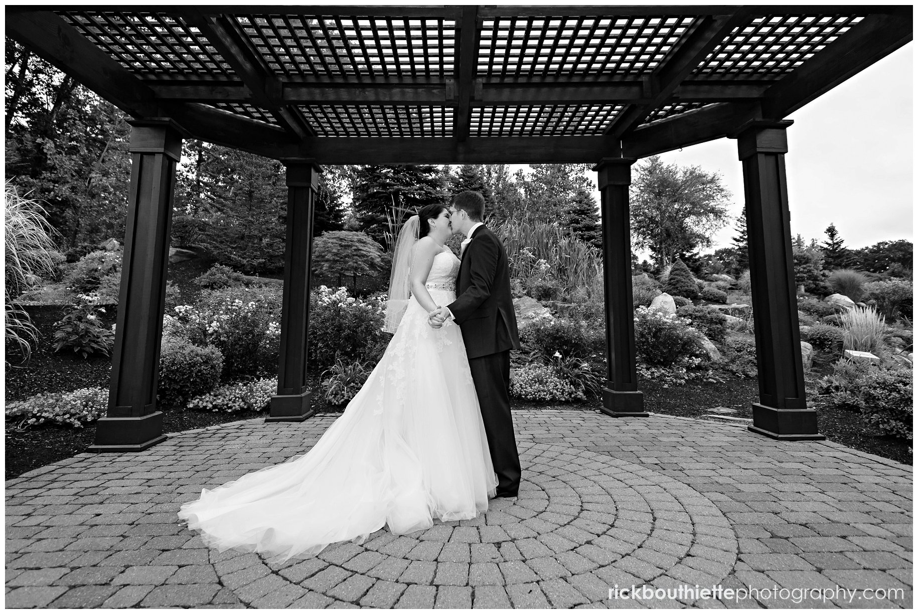 bride & groom share a moment under trellis at atkinson country club