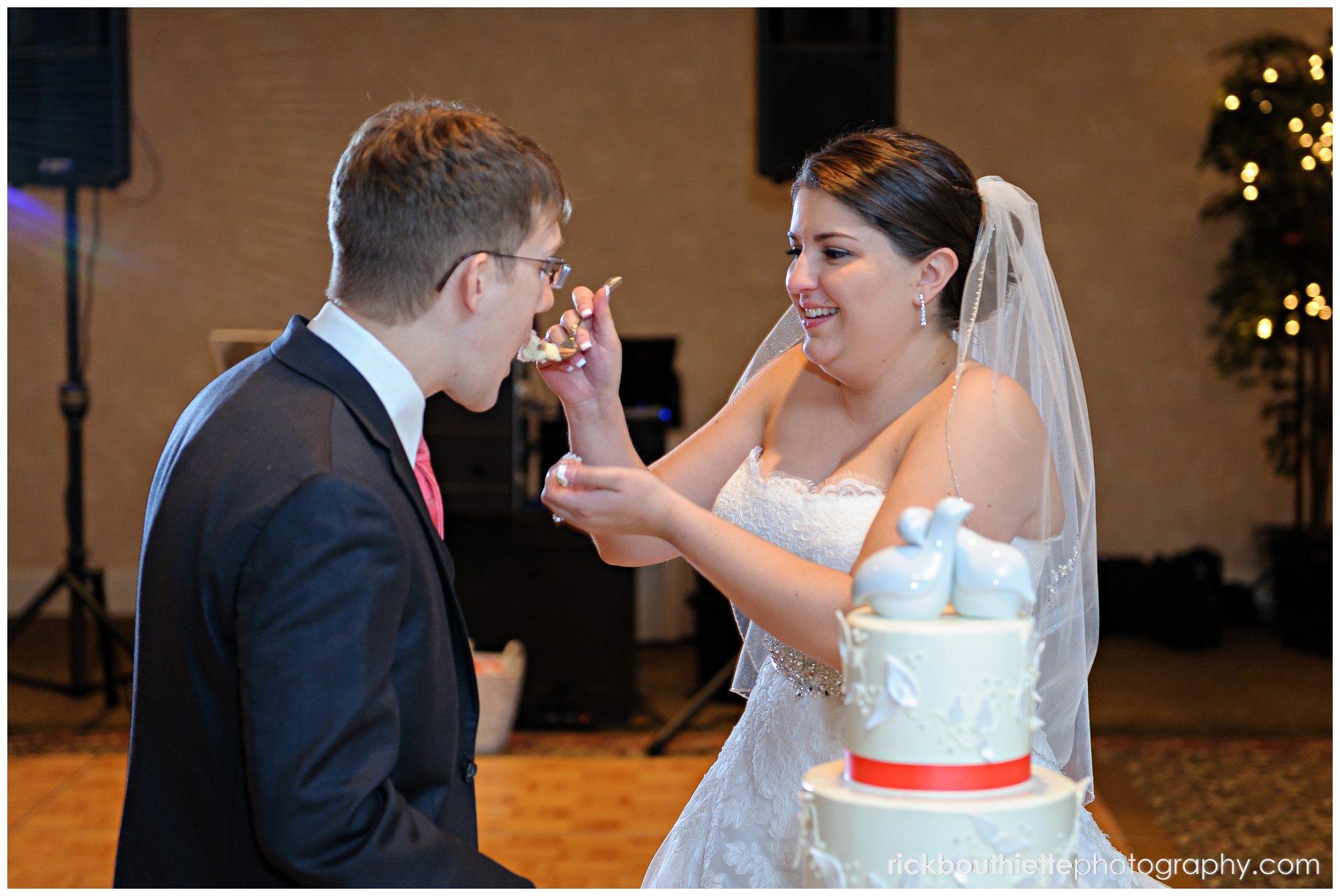 bride feeding the groom cake at wedding