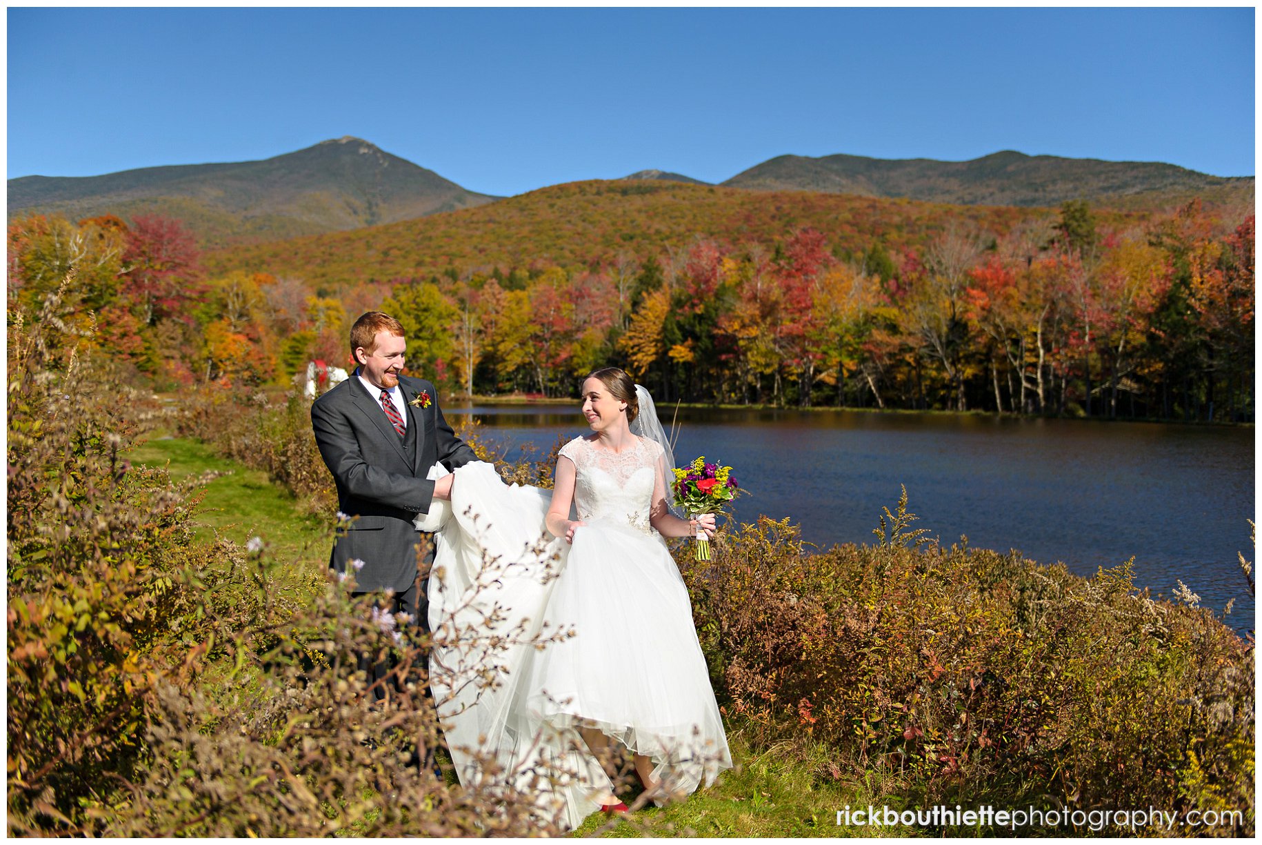 bride and groom walking with fall colors in background at Indian Head Resort wedding