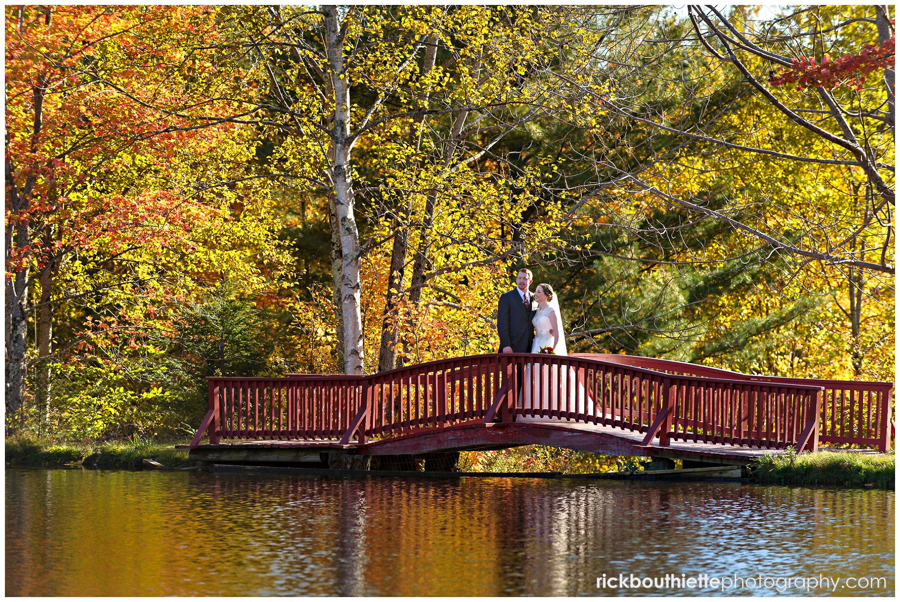 bride and groom on red bridge at Indian Head Resort fall wedding