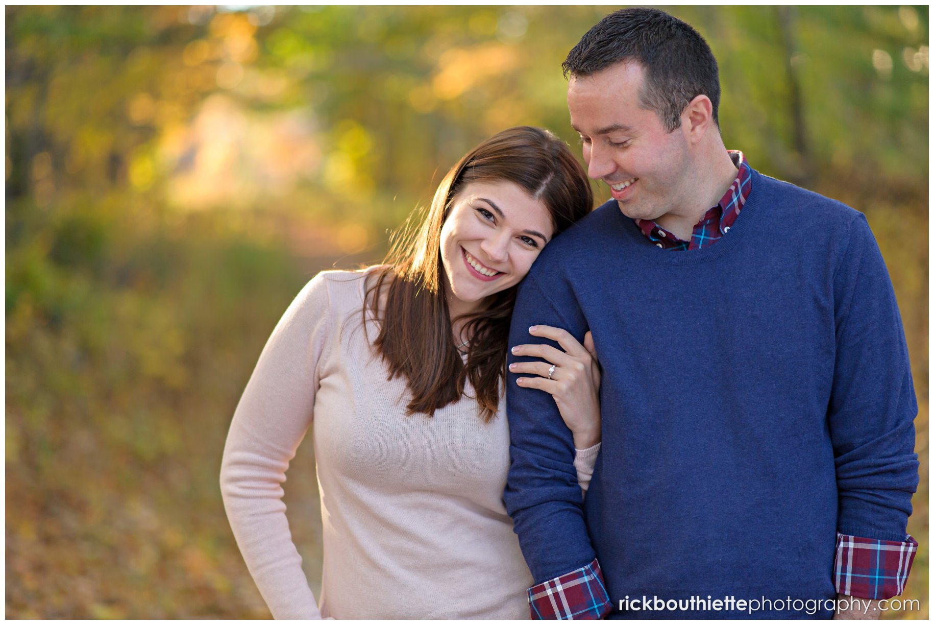 couple walking arm in arm on country path during fall engagement session