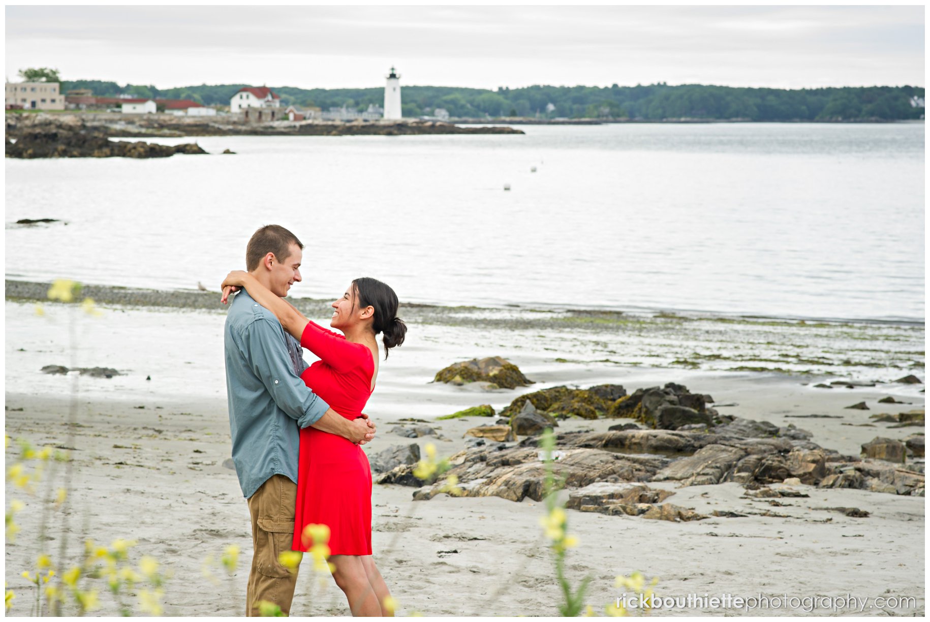 couple on the beach at Great Island Commons with lighthouse in the background during seacoast engagement session