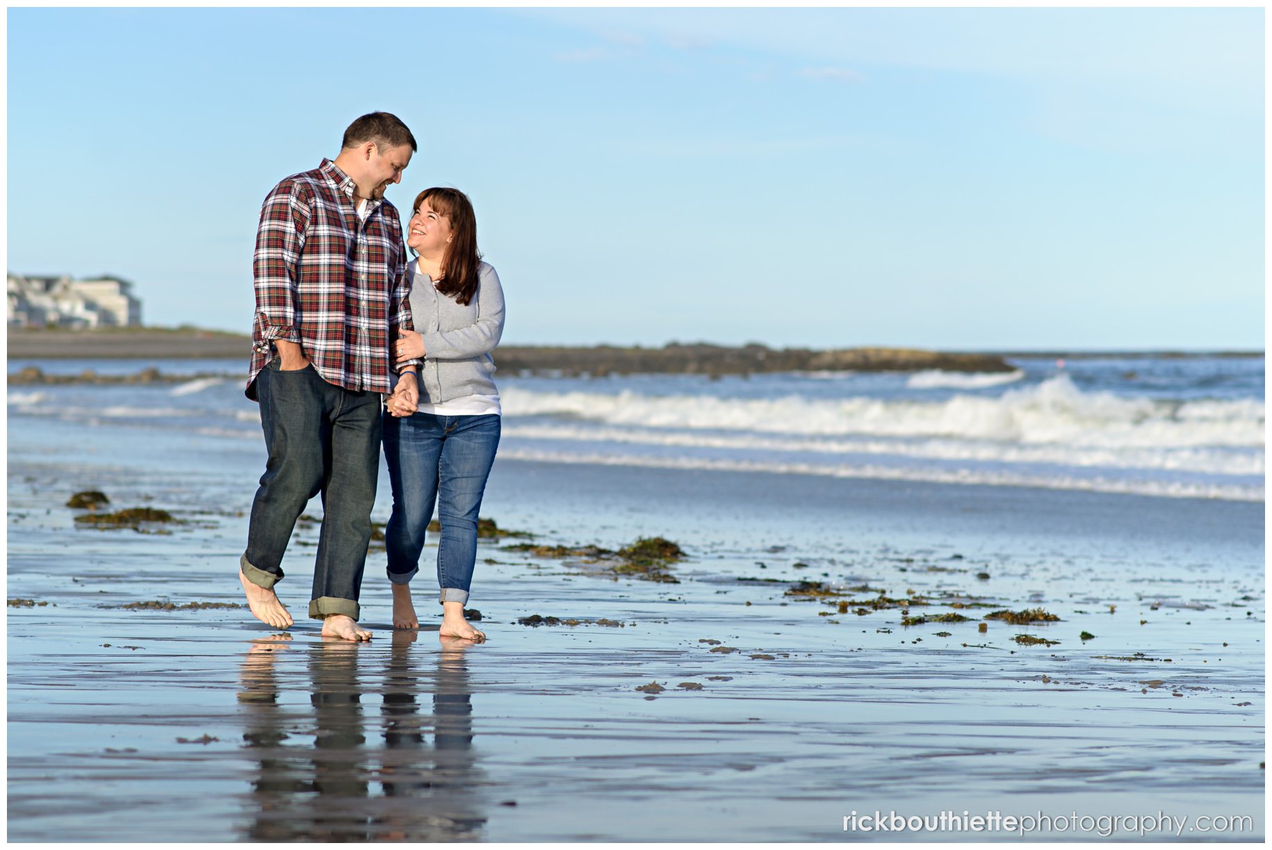 couple walking barefoot on beach during NH seacoast engagement session