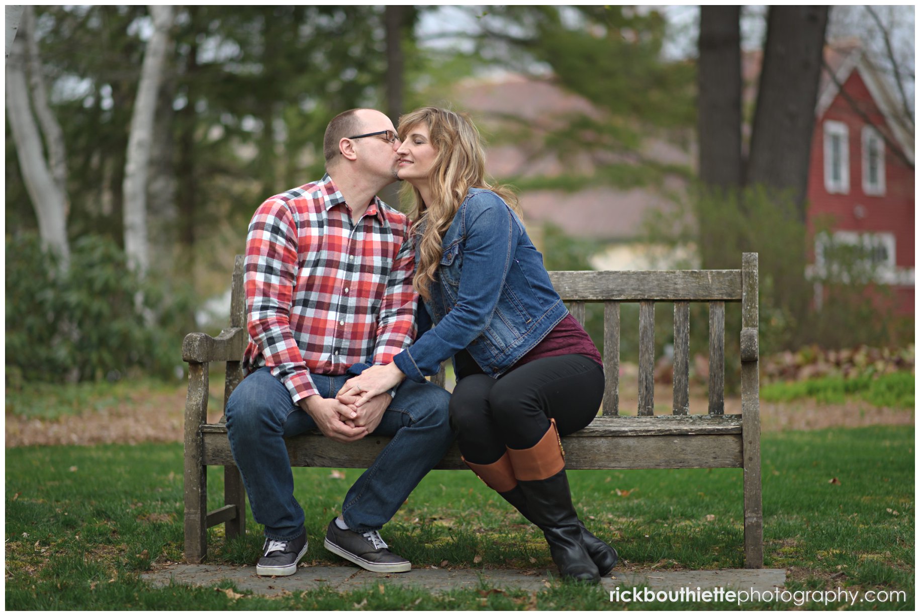 couple sitting on bench kissing at Kirkwood Gardens during lakes region engagement photography