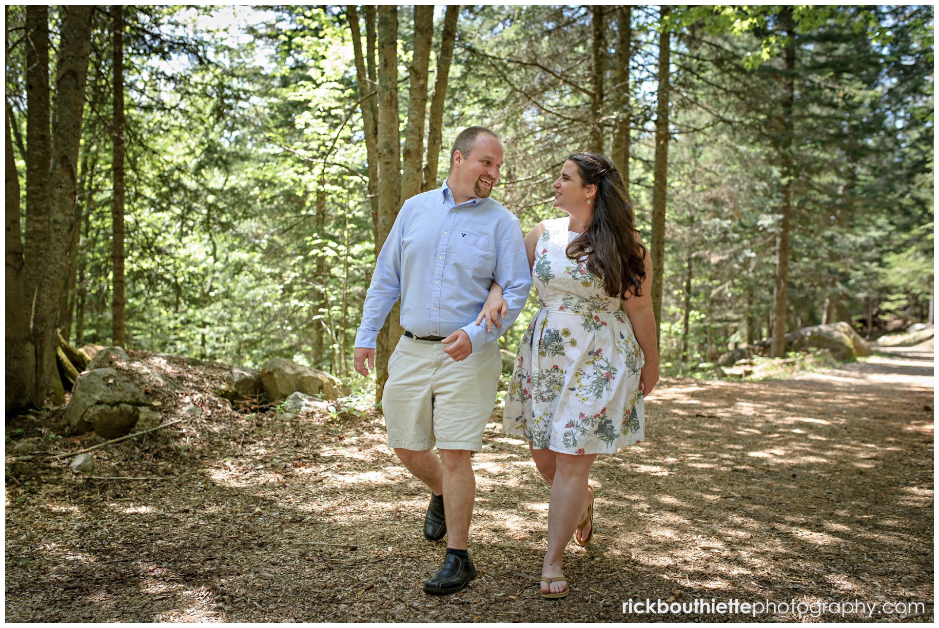 Couple walking on wooded path at omni mount washington resort engagement session