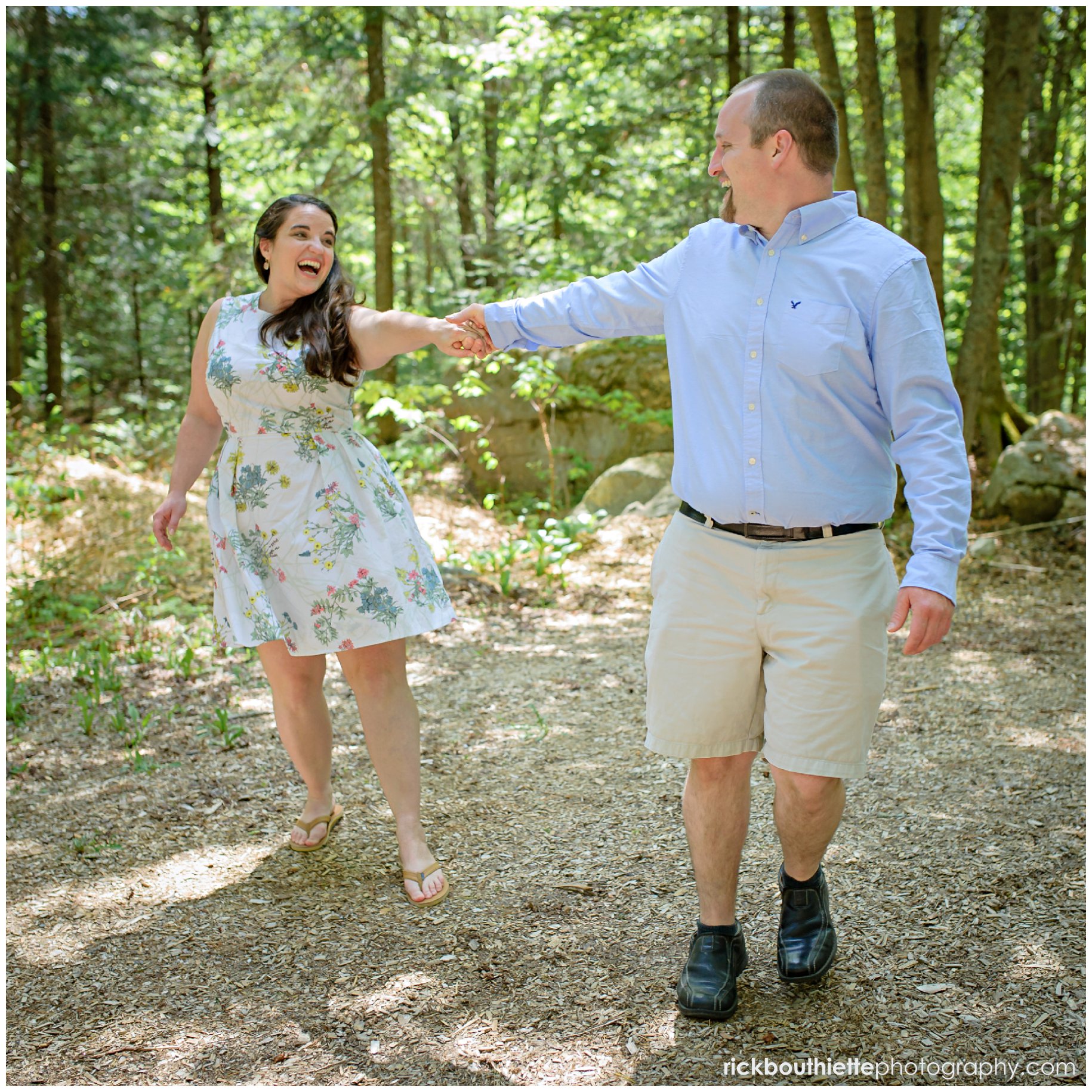 couple having fun on wooded path at omni mount washington engagement session