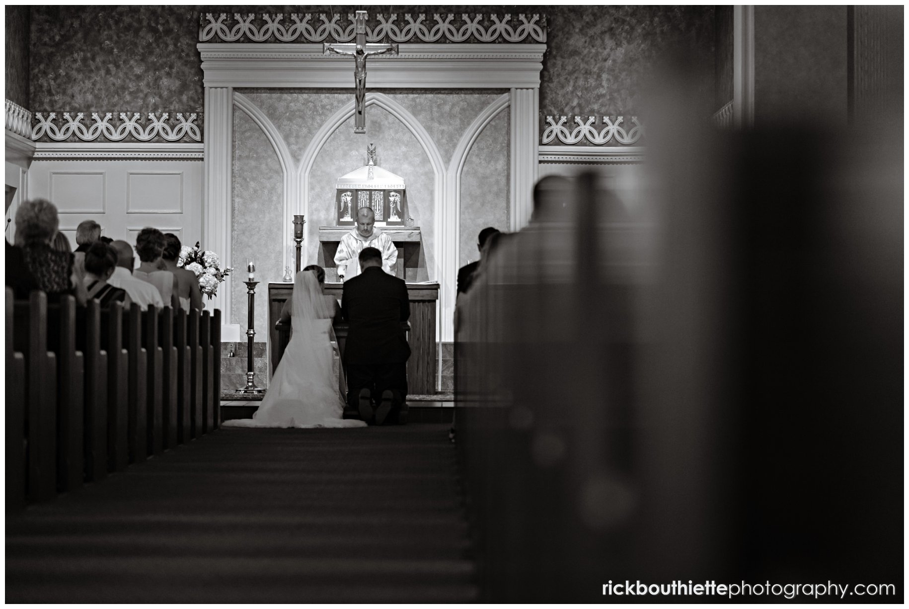 black & white picture of bride & groom kneeling at alter at seacoast NH wedding ceremony