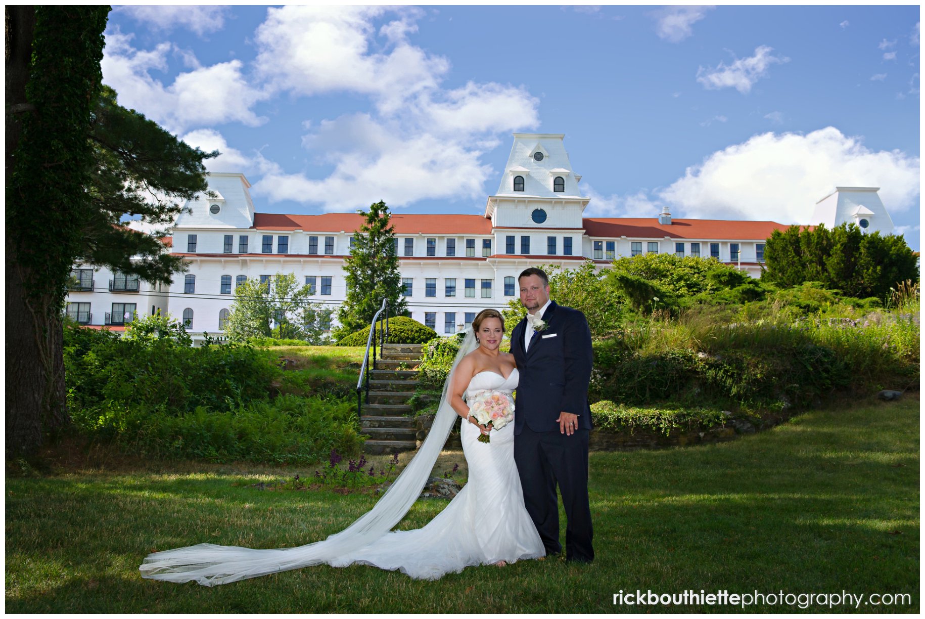 bride and groom in the garden with the hotel in the background at Wentworth By The Sea wedding