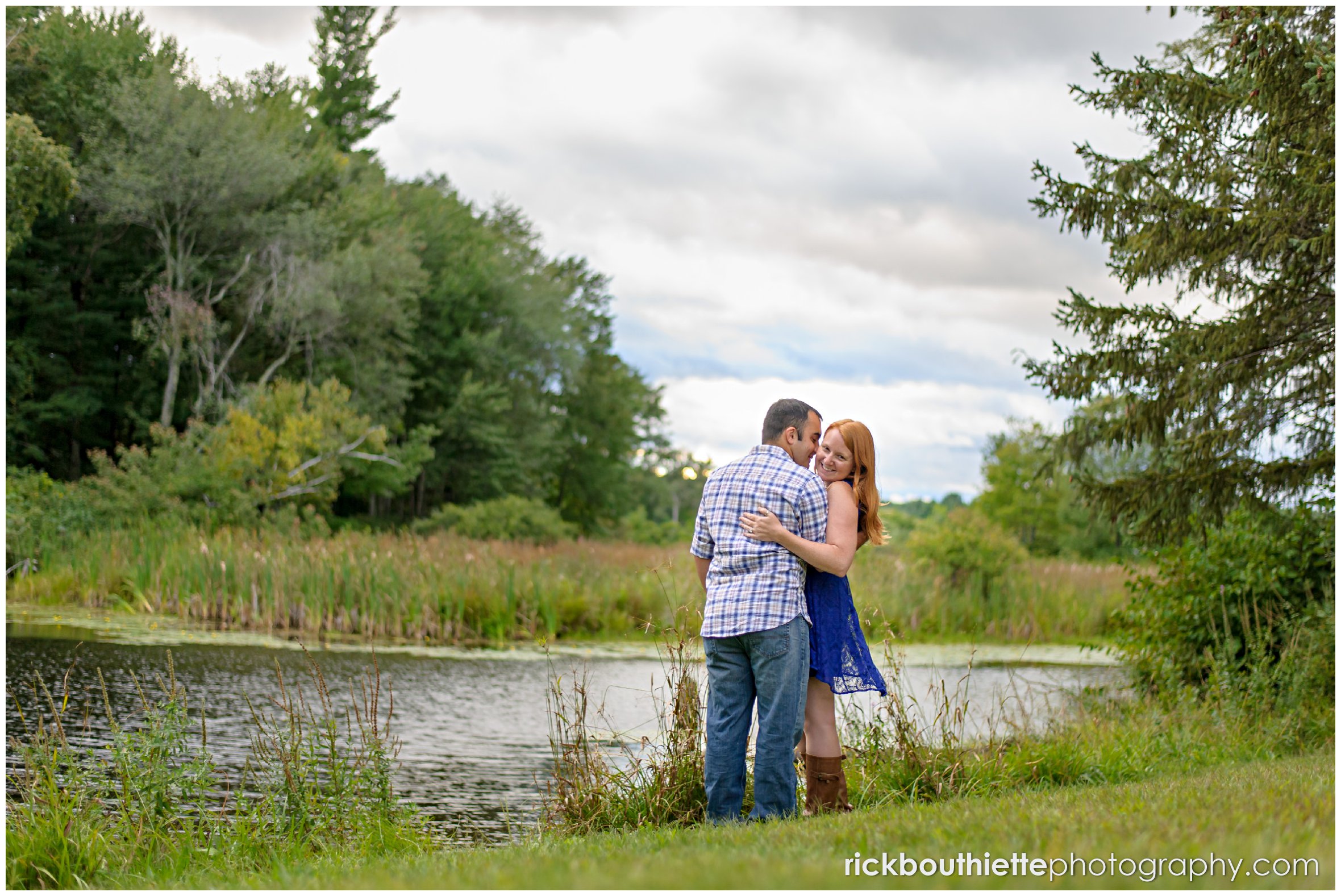 couple kissing by the water at engagement session