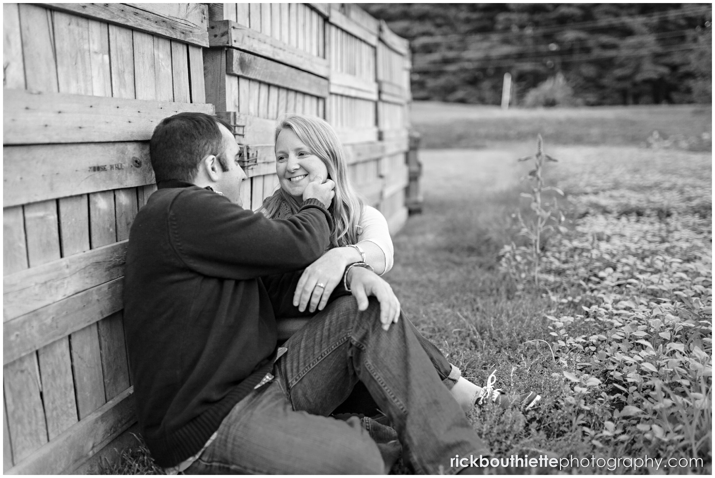 couple sitting againd apple crates at Mack's Apples during engagement session