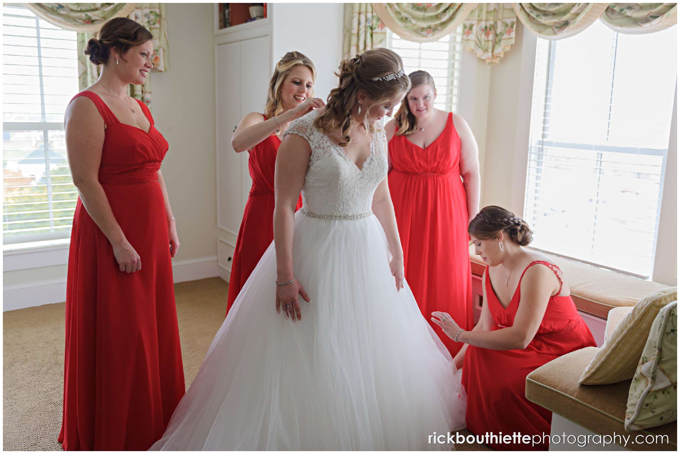 bride surrounded by her bridesmaids helping her get ready for her mountain view grand wedding