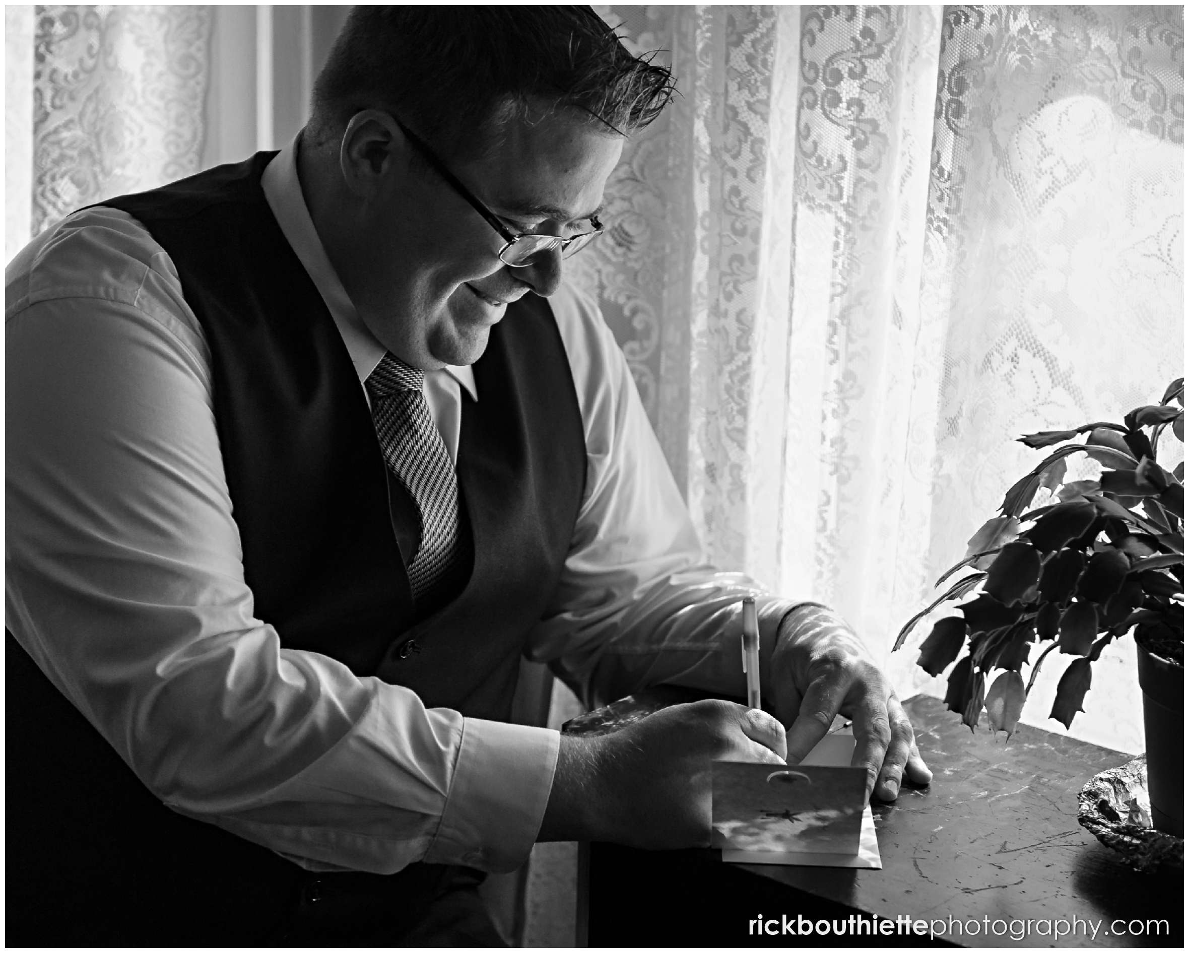 black & white of groom writing a letter to his bride to be