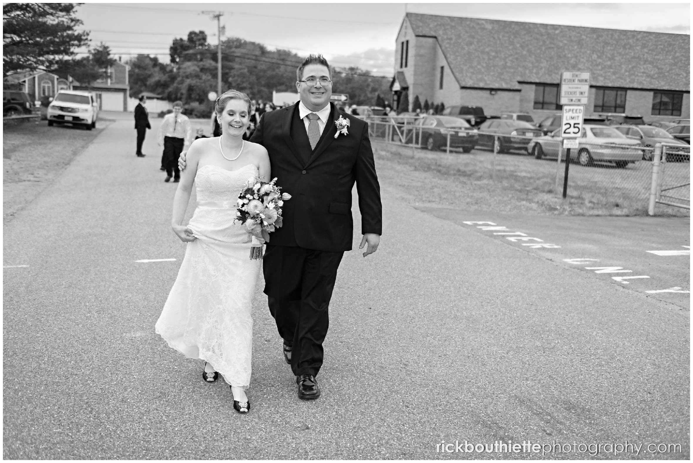 bride and groom walking down street to beach at seacoast wedding