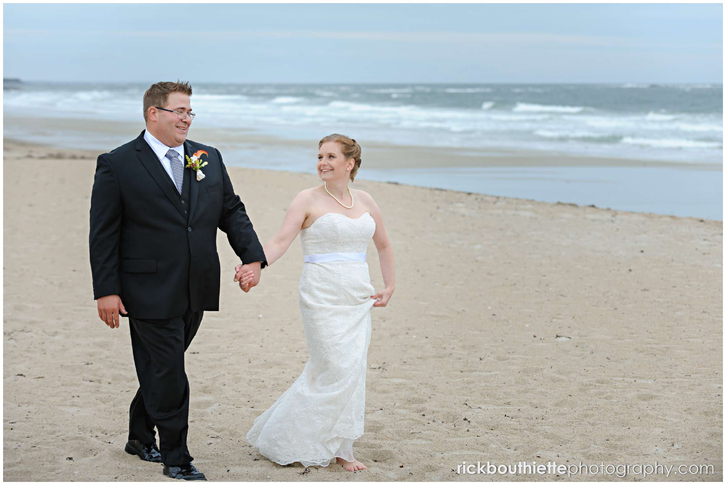 bride and groom walking on Seabrook beach after their seacoast wedding ceremony