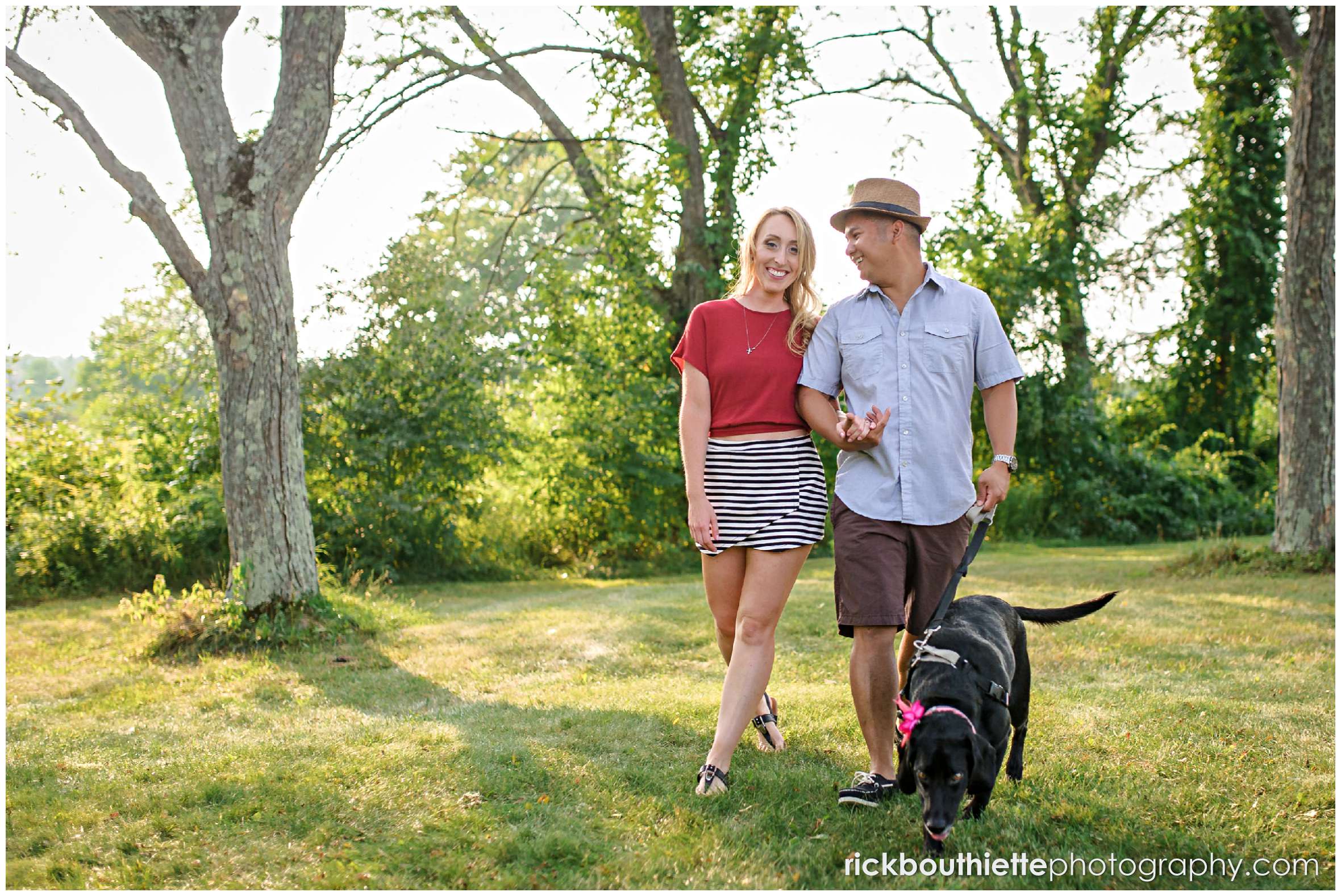 couple walking with their dog during New Hampshire apple orchard engagement session