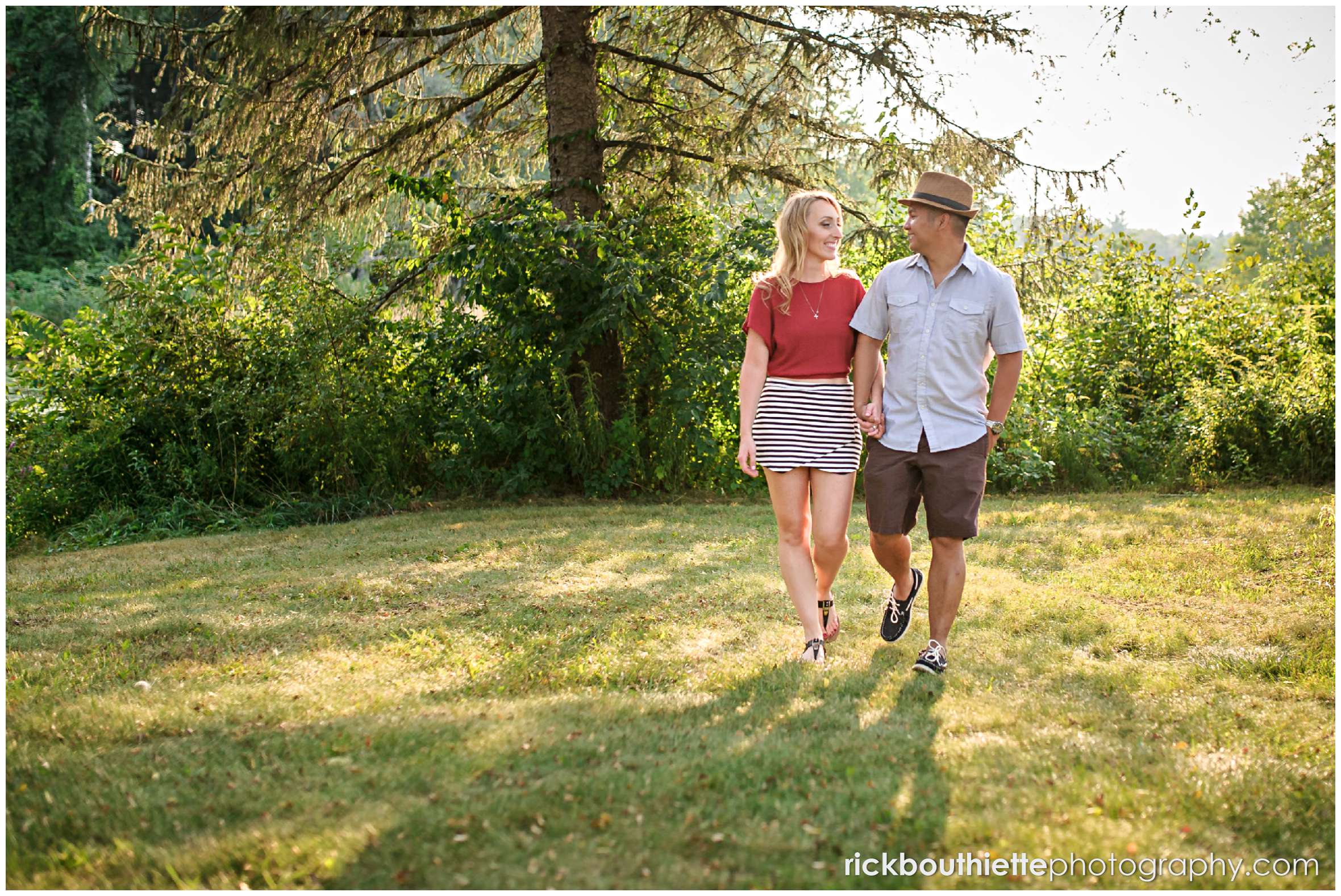 couple walking while holding hands during New Hampshire apple orchard engagement session