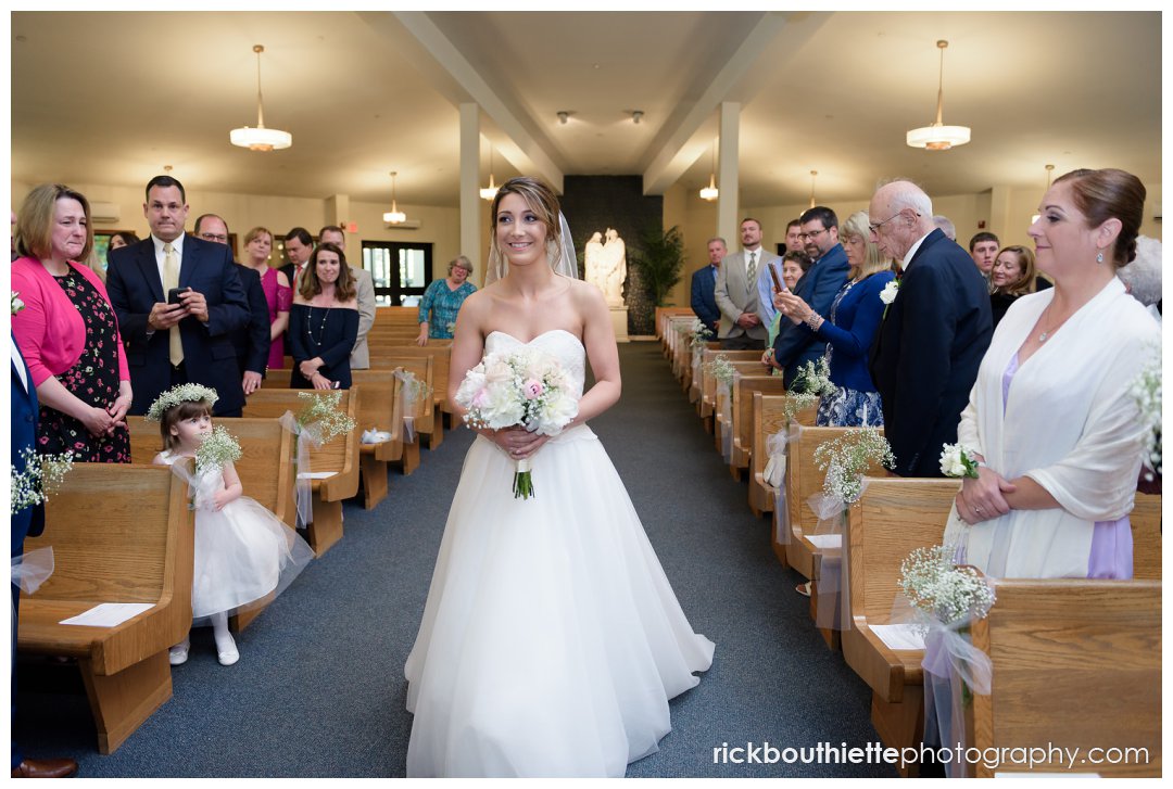 bride coming down aisle at her wedding ceremony at Our Lady of Mercy wedding in southern New Hampshire