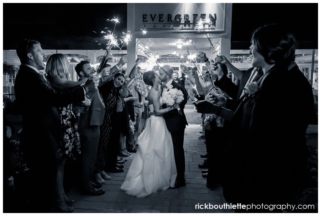 bride and groom kiss during their sparkler exit at Candia Woods Evergreen Pavilion wedding reception