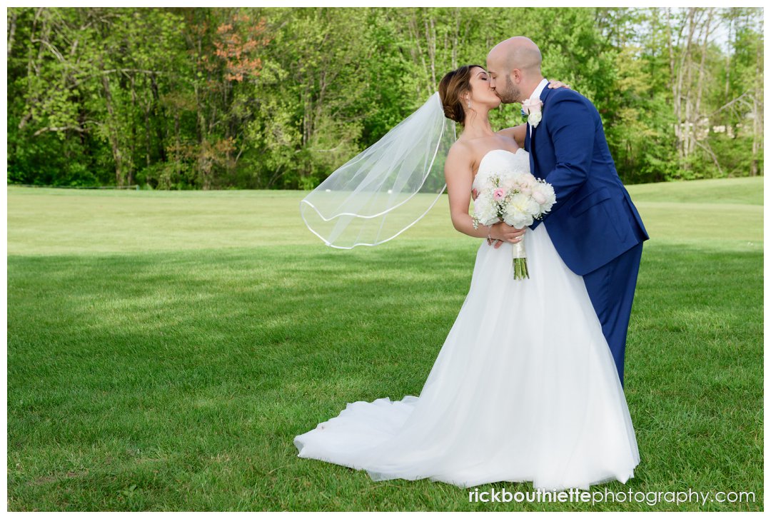 bride and groom stop for a kiss at Candia Woods wedding
