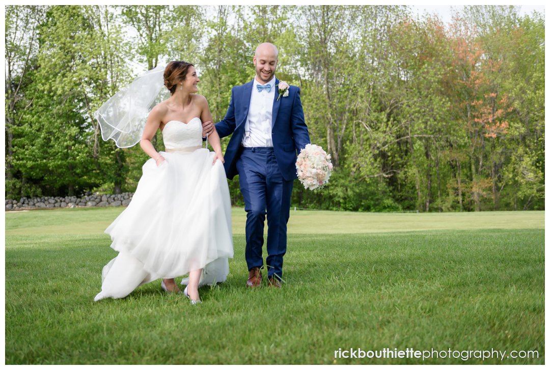 bride and groom walking across lawn at Candia Woods Wedding