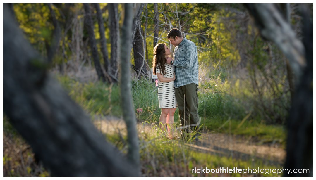 couple pauses on path for a romantic moment during their seacoast engagement session