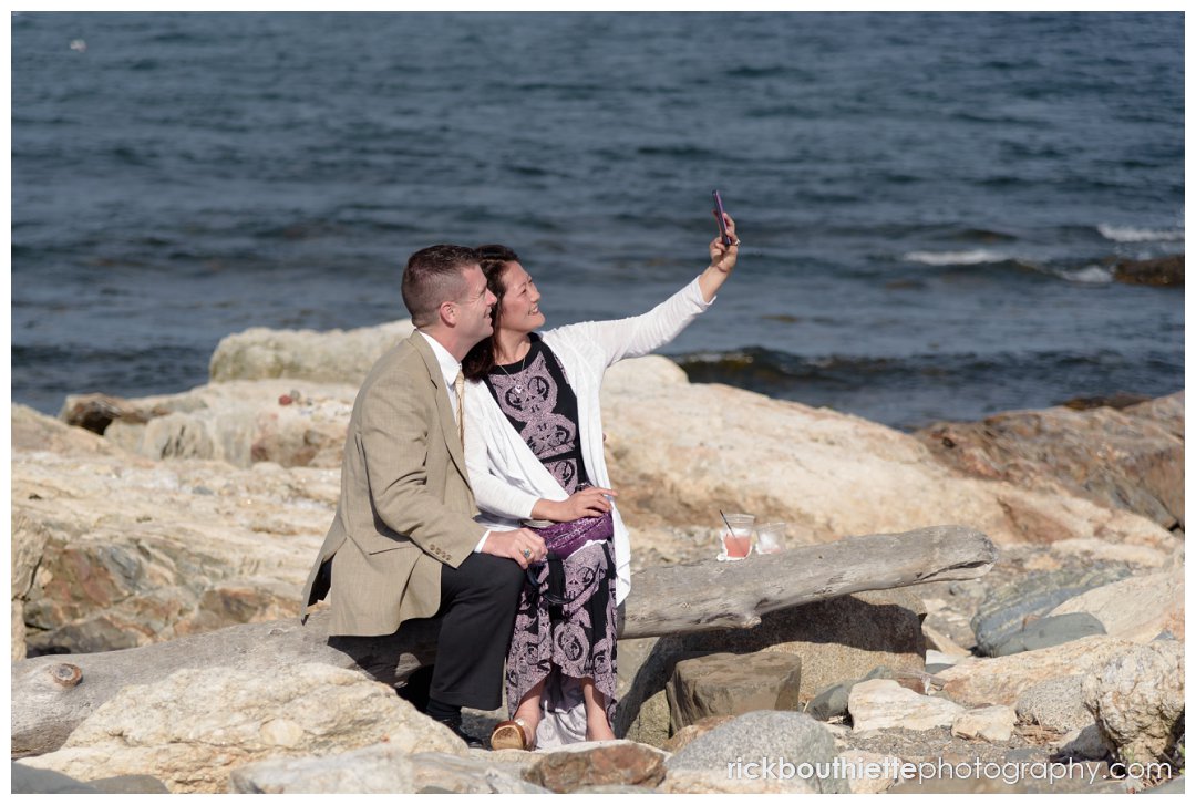 guest couple taking a selfie at the water's edge at New Hampshire Seacoast Science Center wedding