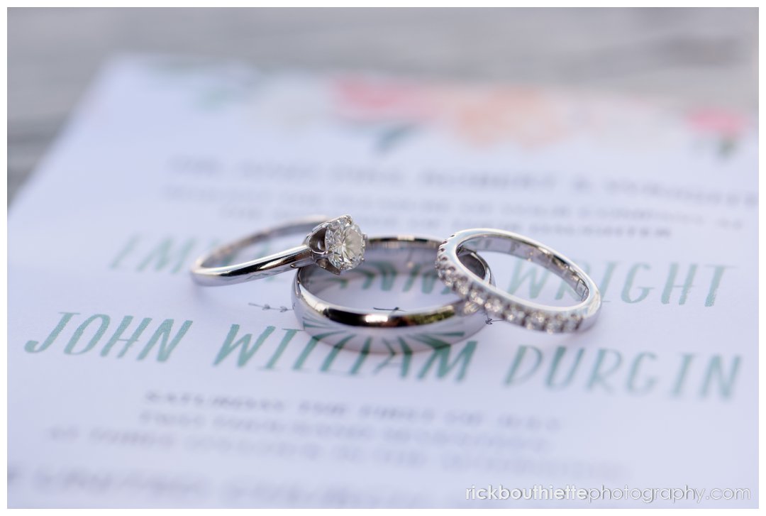 closeup of wedding rings on wedding invitation
