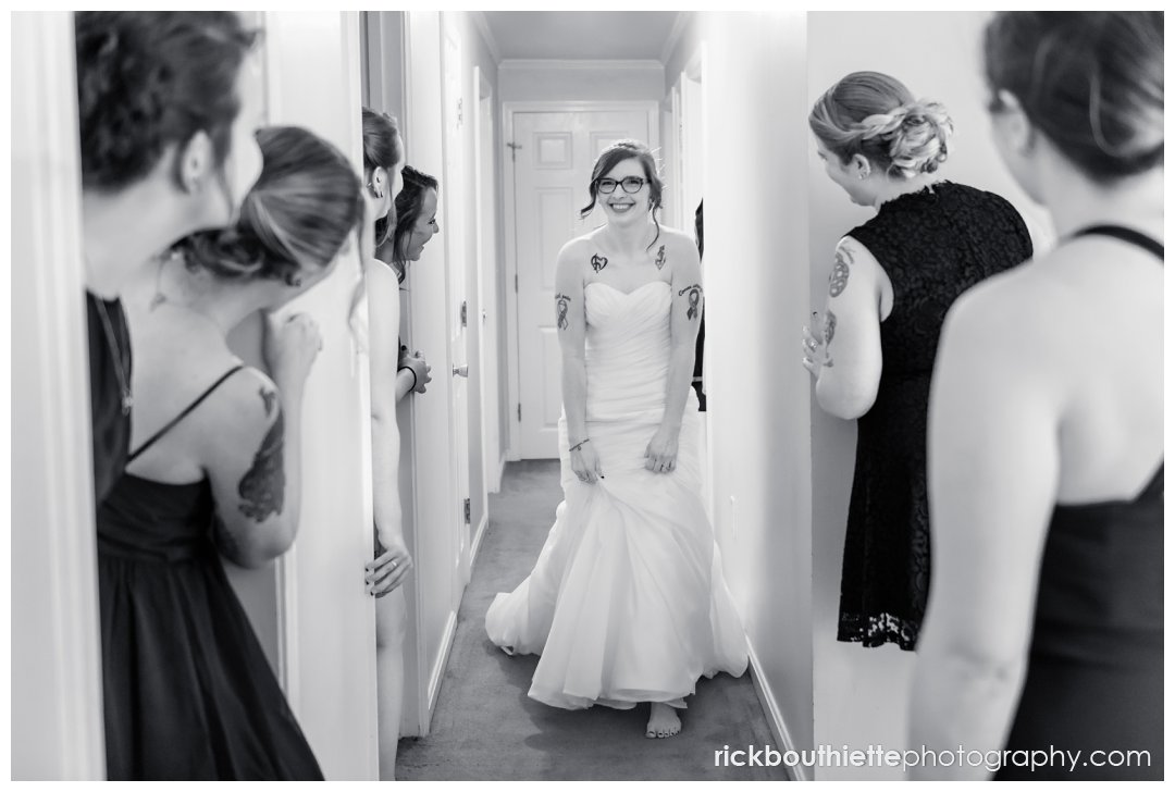 bridesmaids admire bride walking down hallway in her wedding dress