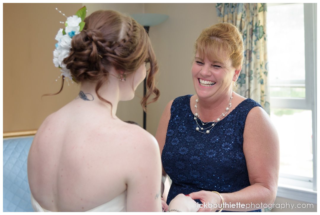 mother of the bride has a happy moment with the bride as they get ready for her New Hampshire backyard summer wedding
