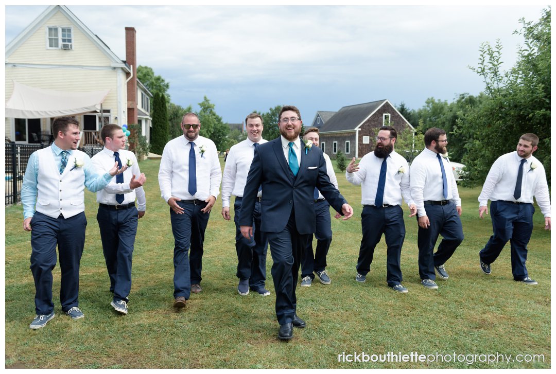 groom and groomsmen entering ceremony at New Hampshire backyard summer wedding