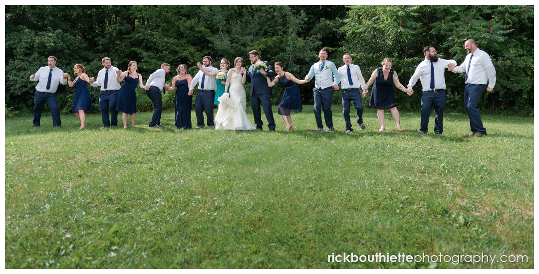 wedding party celebrating with bride and groom after New Hampshire backyard summer wedding ceremony