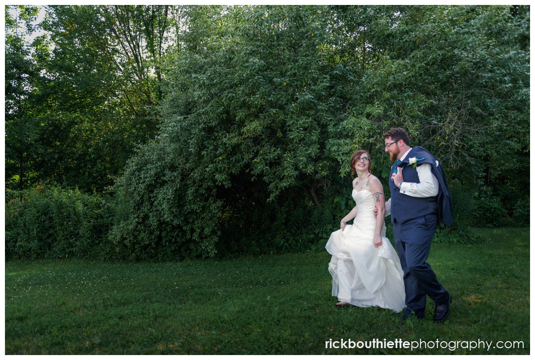 bride and groom walking their New Hampshire backyard summer wedding reception