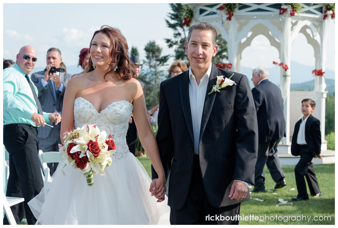 bride and groom walk down aisle after wedding ceremony